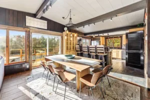 Dining room with tables, chairs, a bar, patio door and windows