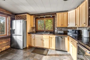 Kitchen with dishwasher refrigerator, windows, and cabinets